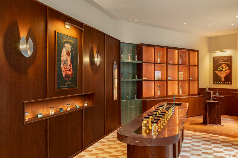 A modern perfume boutique interior with wooden shelves, display tables holding perfume bottles, and vintage-style posters on the walls.