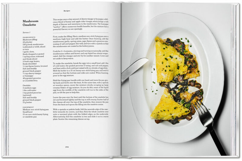 An open cookbook displays a mushroom omelette recipe on the left page and a plated mushroom omelette, ready to taste with a fork and knife, on the right page.