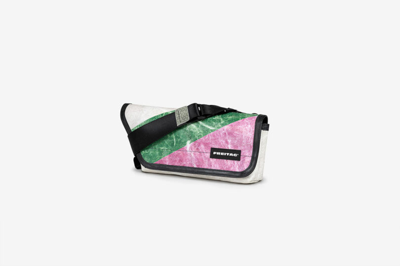 A messenger bag with a pink and green diagonal design, black strap, and a visible FREITAG logo on the front, placed against a plain white background.