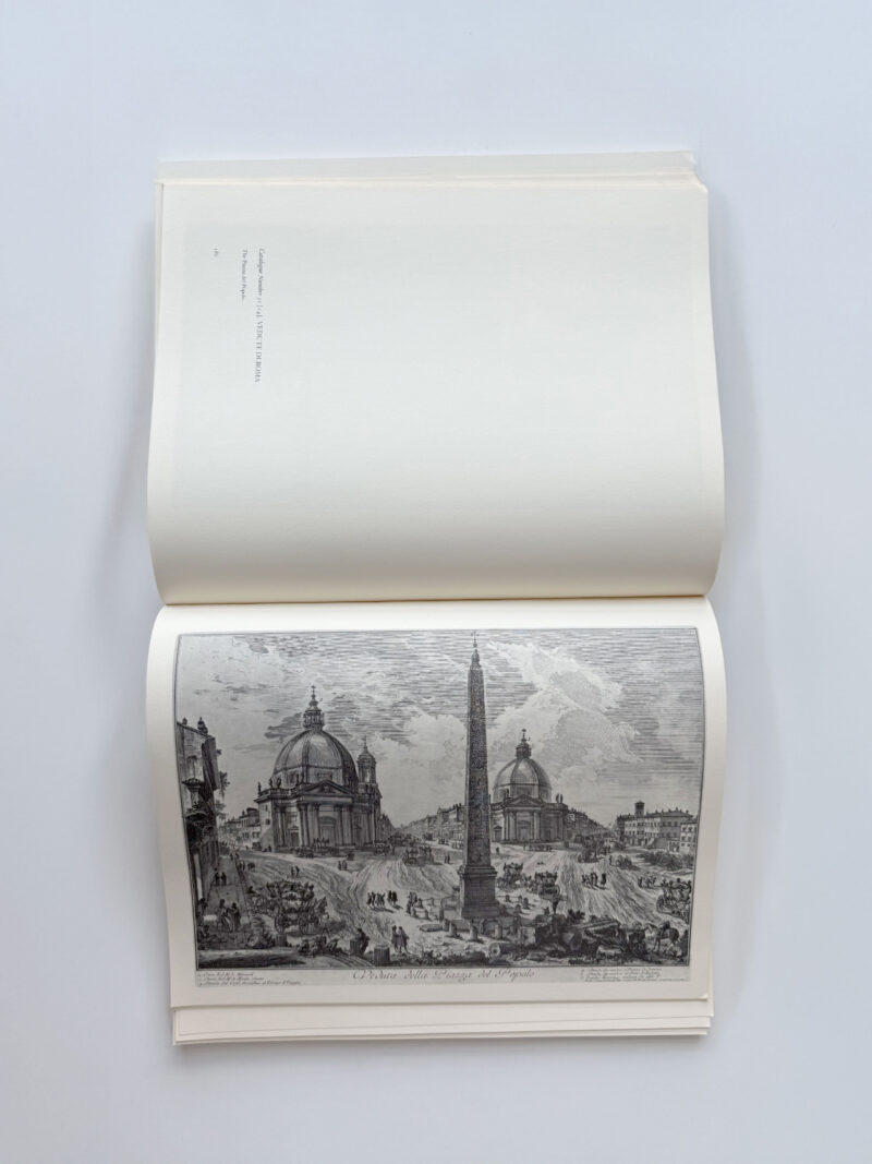 Open book displaying a black-and-white illustration of a city square with two domed buildings, an obelisk in the center, and groups of people in the foreground.