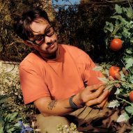 Photo of a man tending to his tomato patch while wearing the Meta Ray-Ban Display glasses and wristband