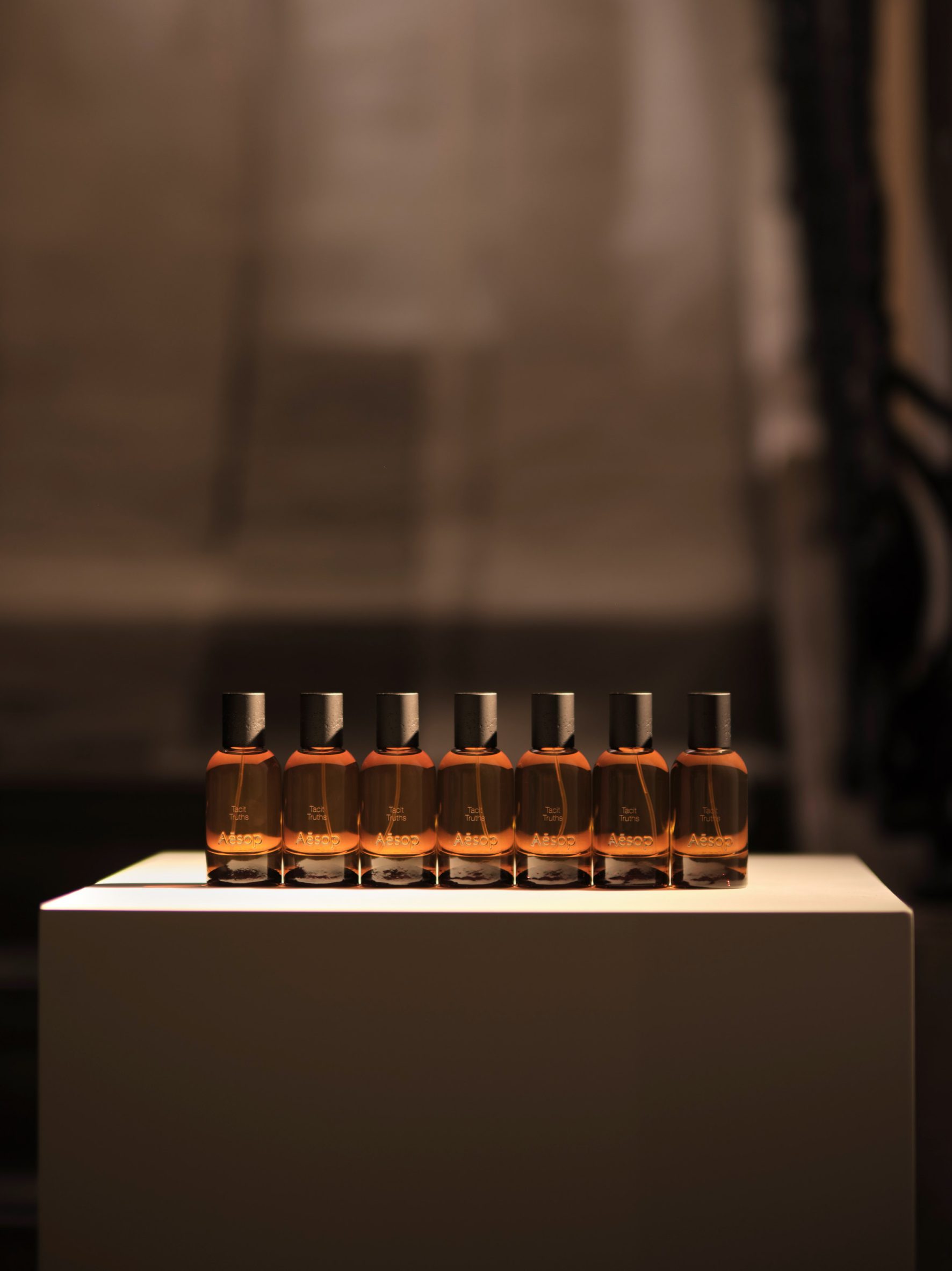 Aesop amber perfume bottles displayed on a stack of paper