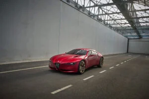 Red Alfa Romeo Cuorerosso sports-car concept with a low profile and sculpted bodywork inside a large industrial building