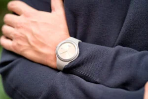 Person in blue jumper wearing metal watch